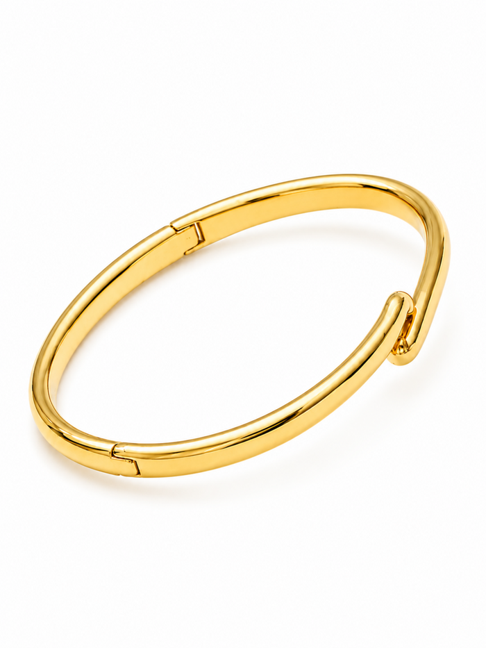 A polished gold-toned metal hinged cuff bracelet, shown on a clean white background.